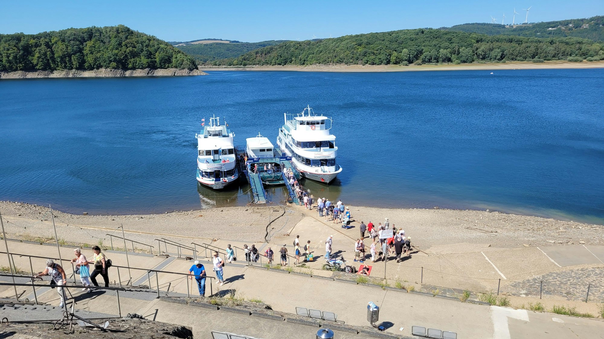 Auf der nur gering gefüllten Rurtalsperre liegen zwei Ausflugsboote der Weißen Flotte.