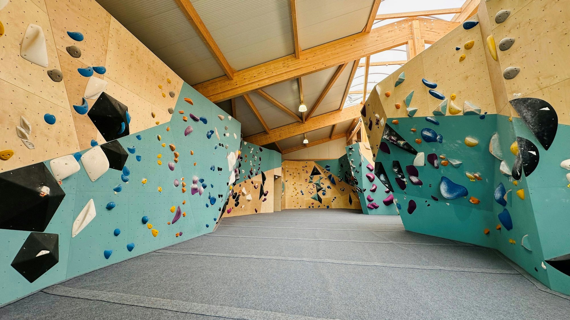 Zu sehen ist eine Boulderhalle mit verschiedenen Kletterwänden.
