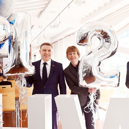 Hauptgeschäftsführer Erik Werdel, Oberbürgermeisterin Henriette Reker, und Ulrich Soenius, Direktor des Kölner Wirtschaftsarchivs, halten Luftballons hoch, die die Zahl 125 zeigen.