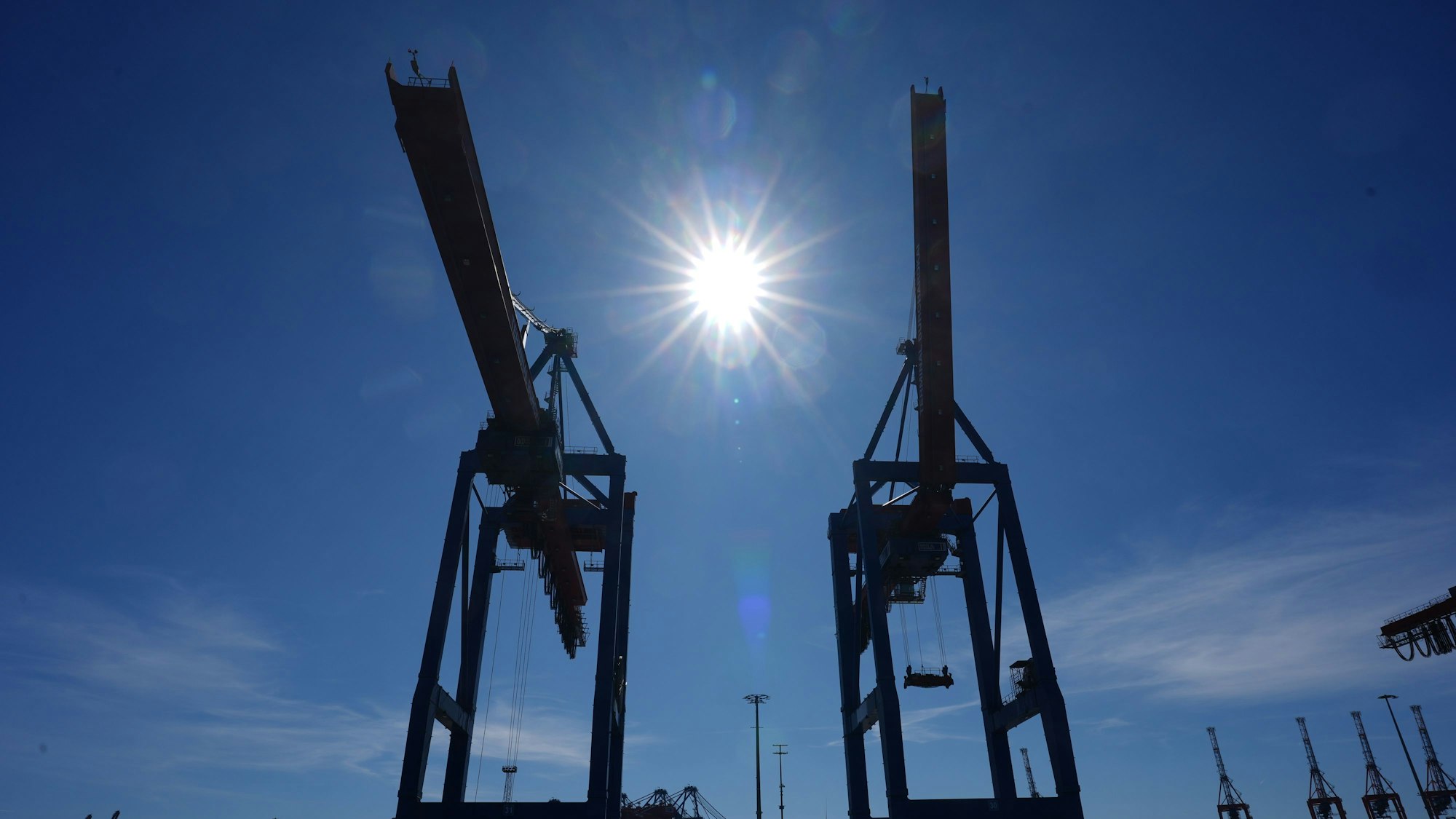 Die Sonne scheint über den Containerbrücken am Containerterminal Burchardkai (CTB) im Hamburger Hafen. US-Präsident Donald Trump hat ein gewaltiges Zollpaket verkündet, das auch die Europäische Union hart trifft. Die US-Regierung führt neue pauschale Zölle in Höhe von zehn Prozent auf die meisten Importe in die Vereinigten Staaten ein.