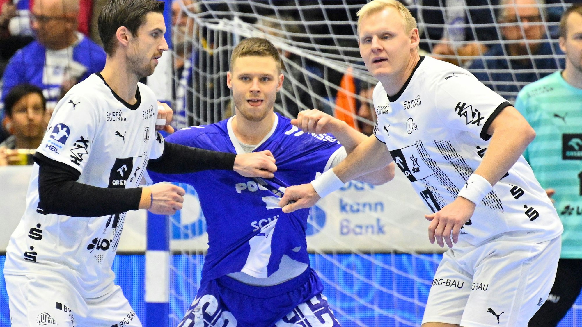Kristjan Horzen im Angriff gegen zwei THW Kiel Spieler.