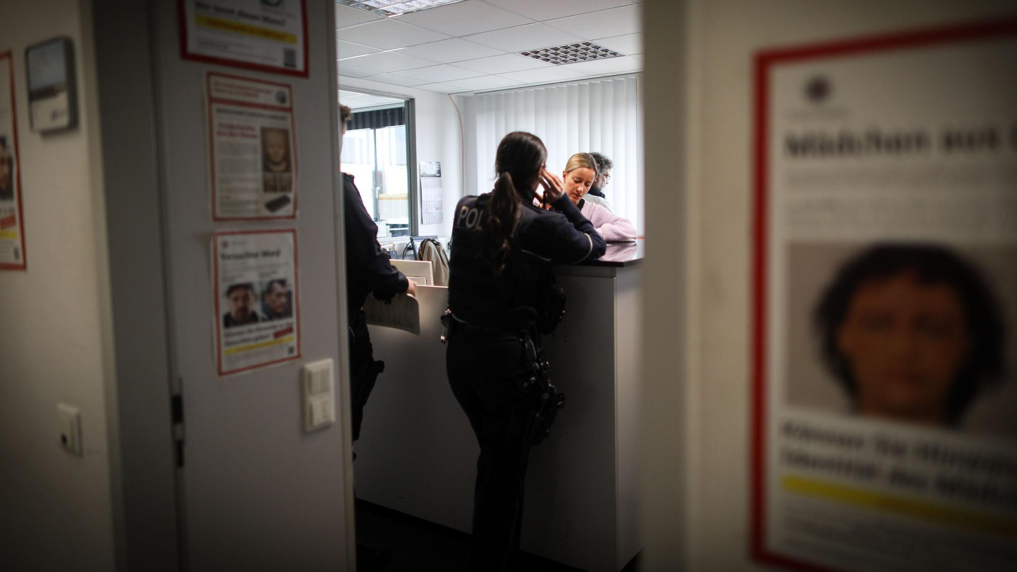 29.03.2025, Köln: Die Fotografie durch einen Eingang gewährt den Blick auf Mitarbeitende einer Kriminalwache.