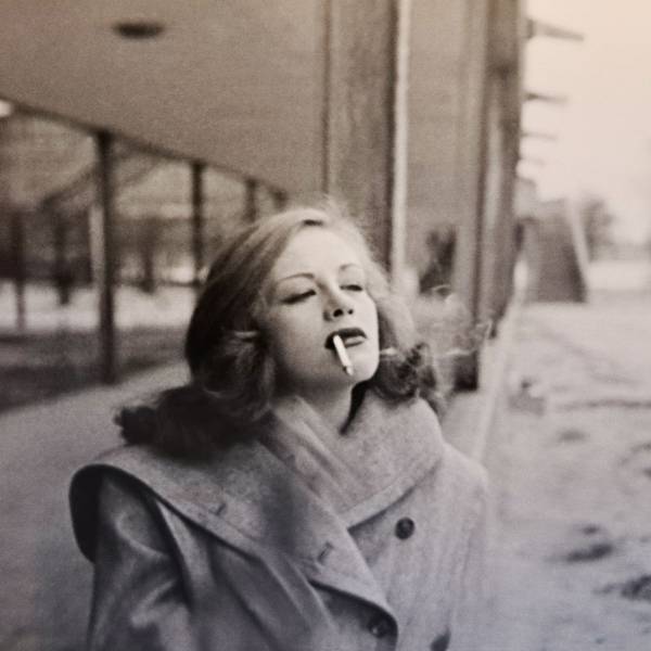Die junge Hildegard Knef spaziert rauchend über eine winterliche Straße.