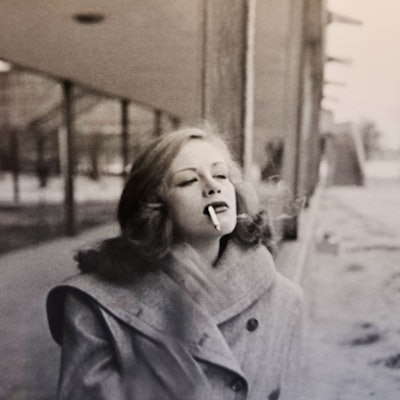 Die junge Hildegard Knef spaziert rauchend über eine winterliche Straße.