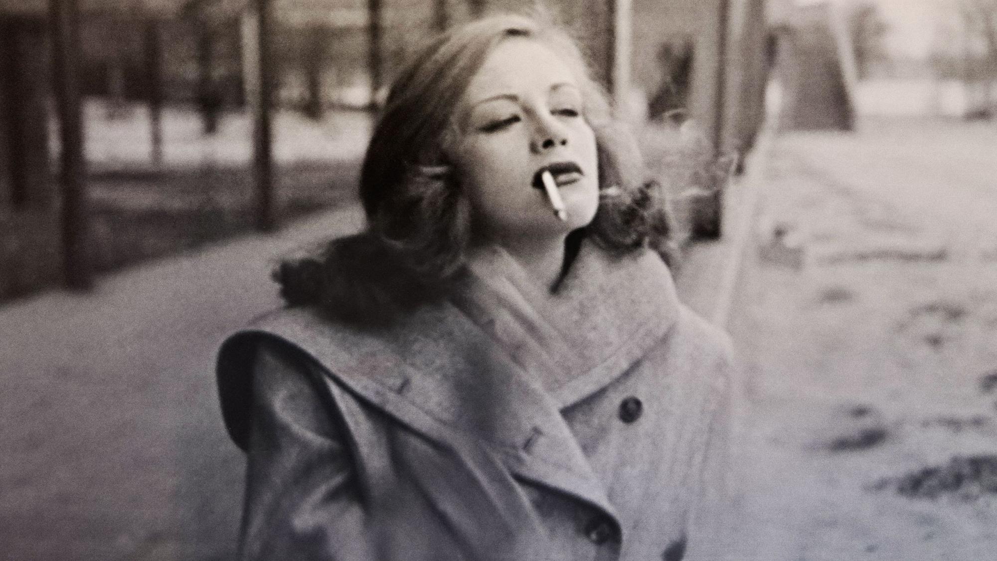 Die junge Hildegard Knef spaziert rauchend über eine winterliche Straße.