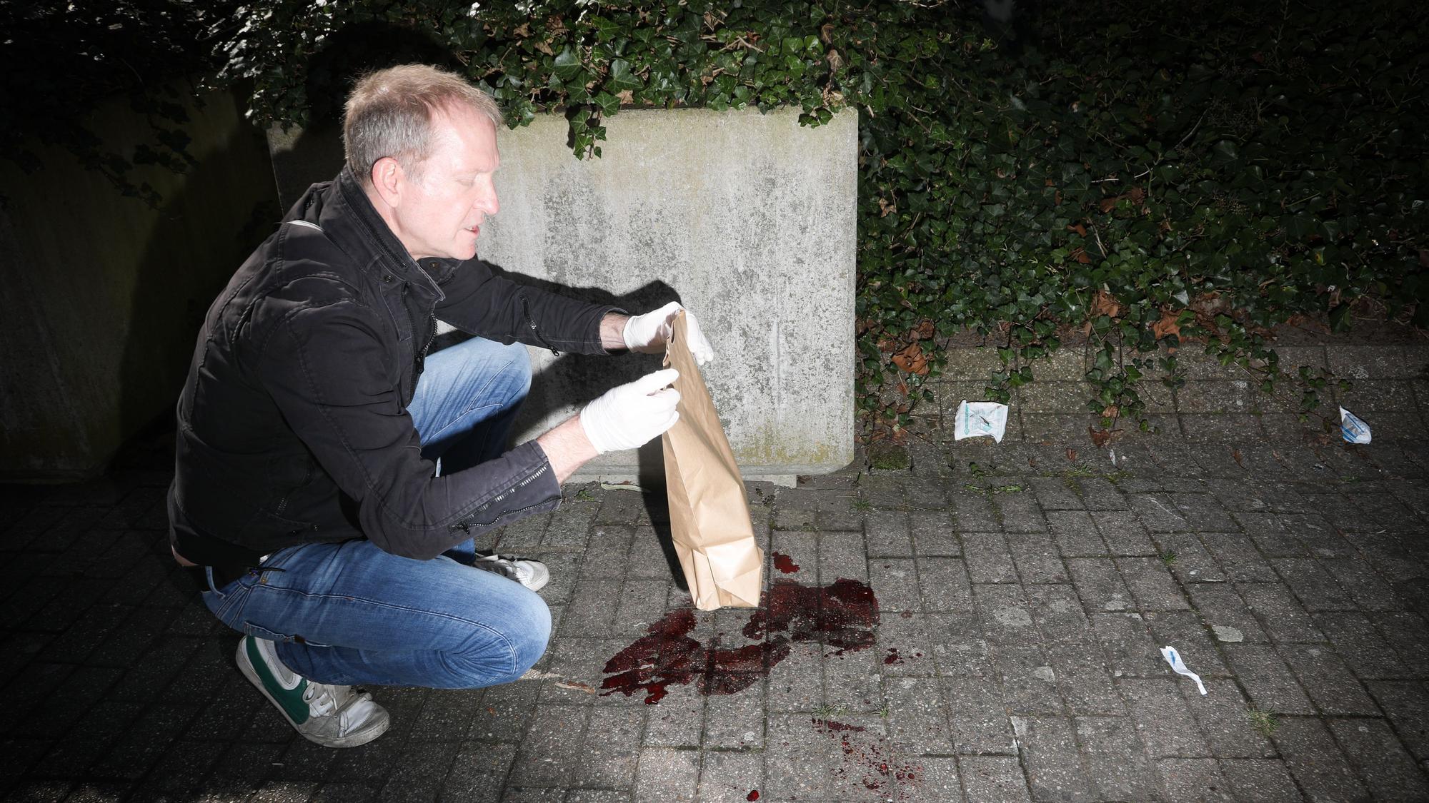 29.03.2025, Köln: Im Dunkeln angeleuchtet kniet Kommisar Volker vor Blutflecken auf Pflastersteinen.
