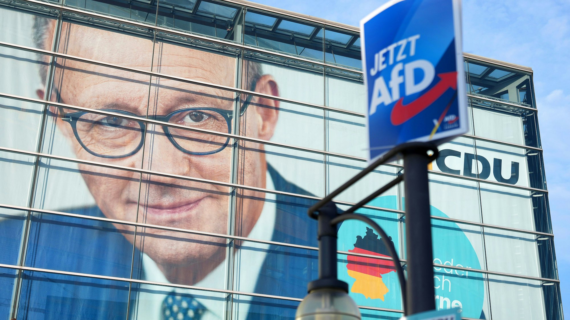 Ein Wahlplakat der AfD hängt vor dem Konrad-Adenauer-Haus mit dem Konterfei des CDU-Bundesvorsitzenden Merz.