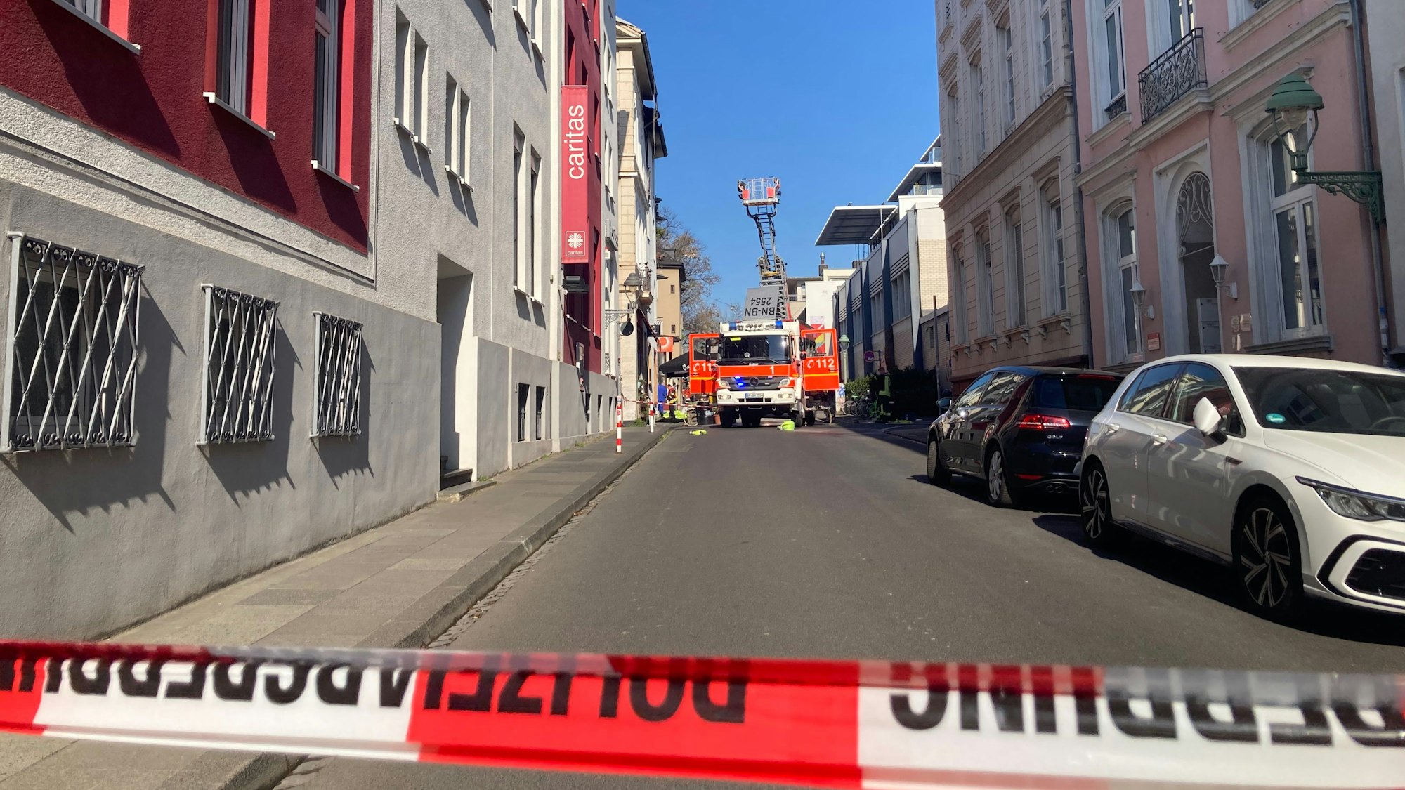 Feuerwehrfahrzeuge stehen in der abgesperrten Fritz-Tillmann-Straße in Bonn. Hier hatte es in einer Dachgeschosswohnung gebrannt.