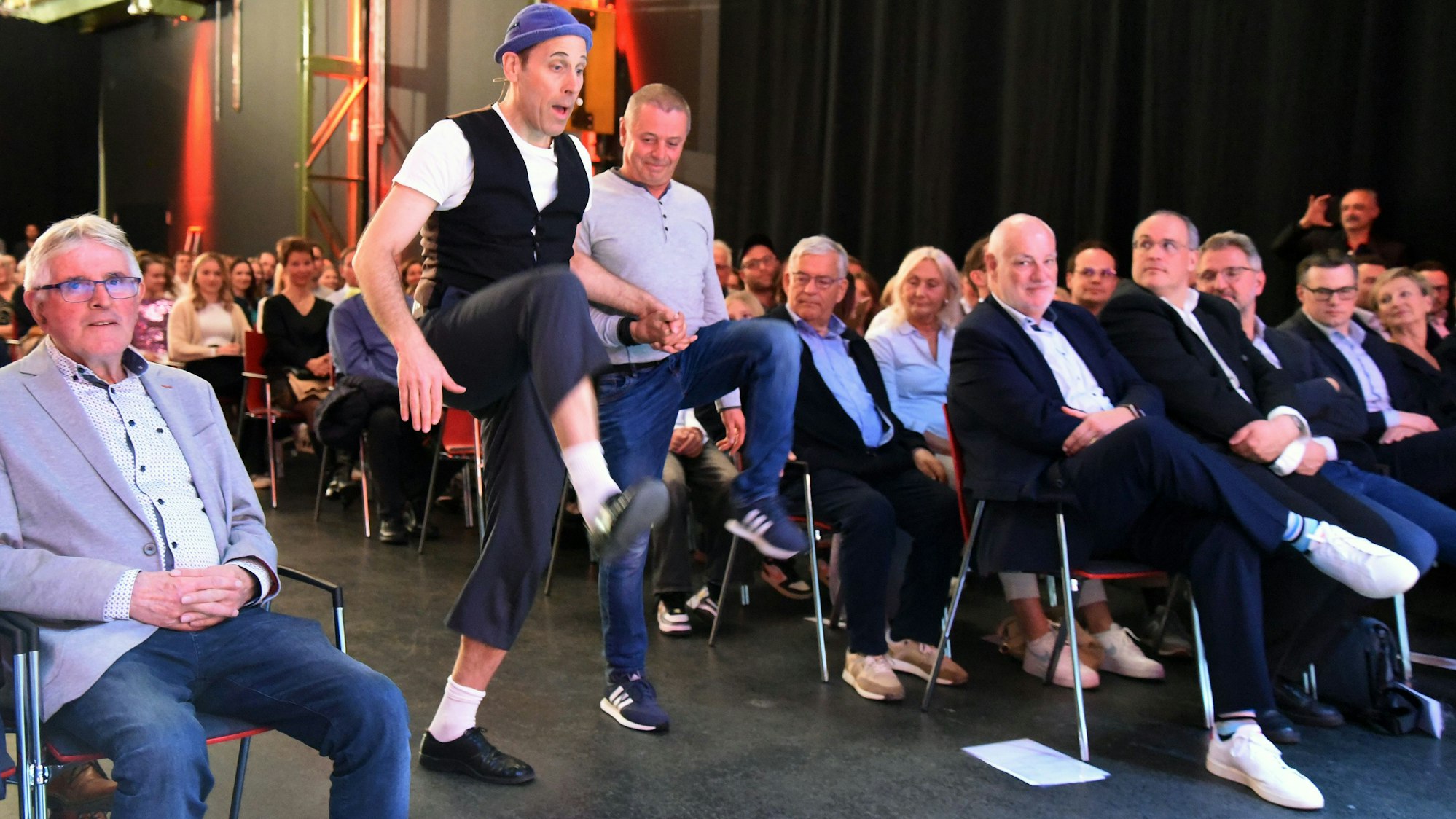 Zu sehen ist ein Zauberer, der mit einem Mann tanzt.