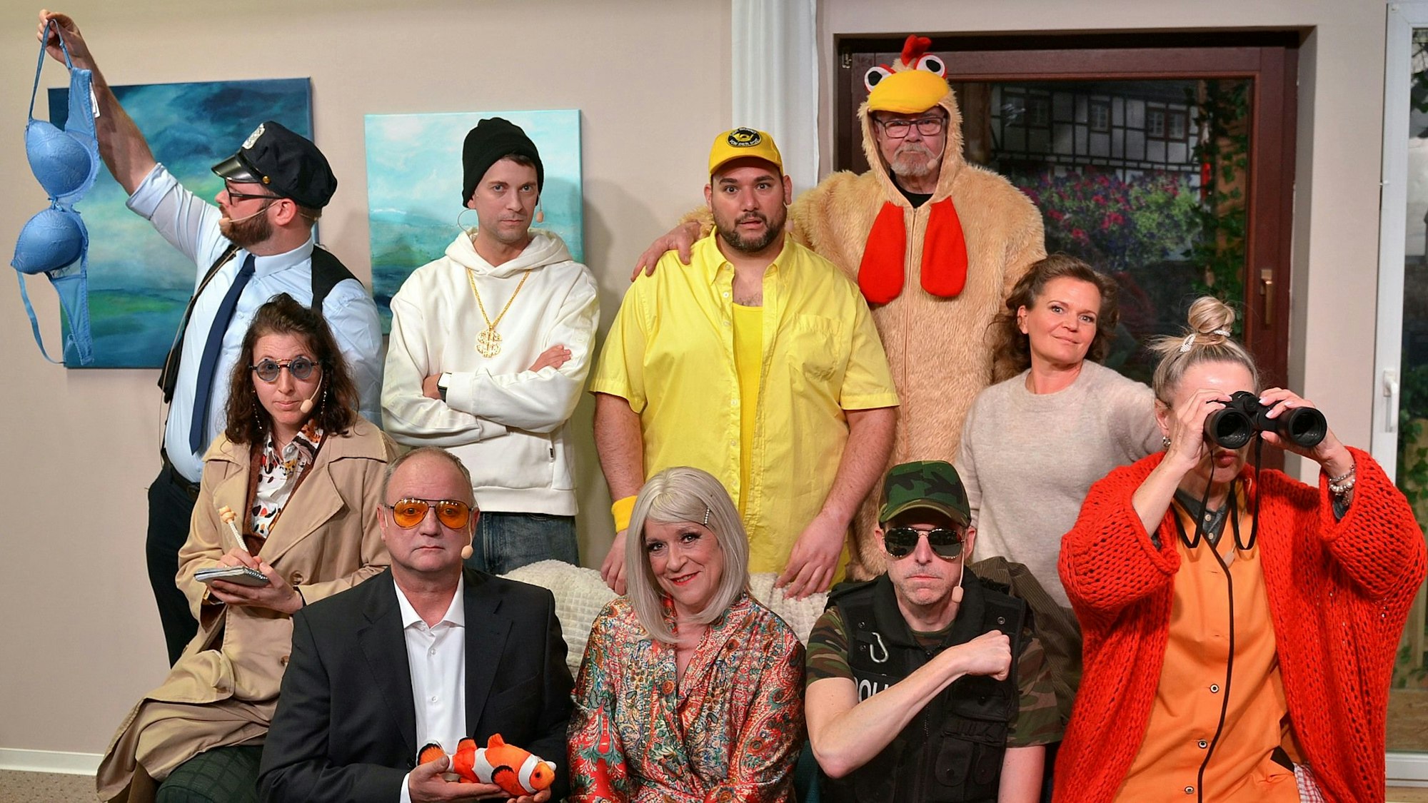 Das Bild zeigt die Schauspielerinnen und Schauspieler, die sich in ihren Kostümen für ein Gruppenbild formiert haben.