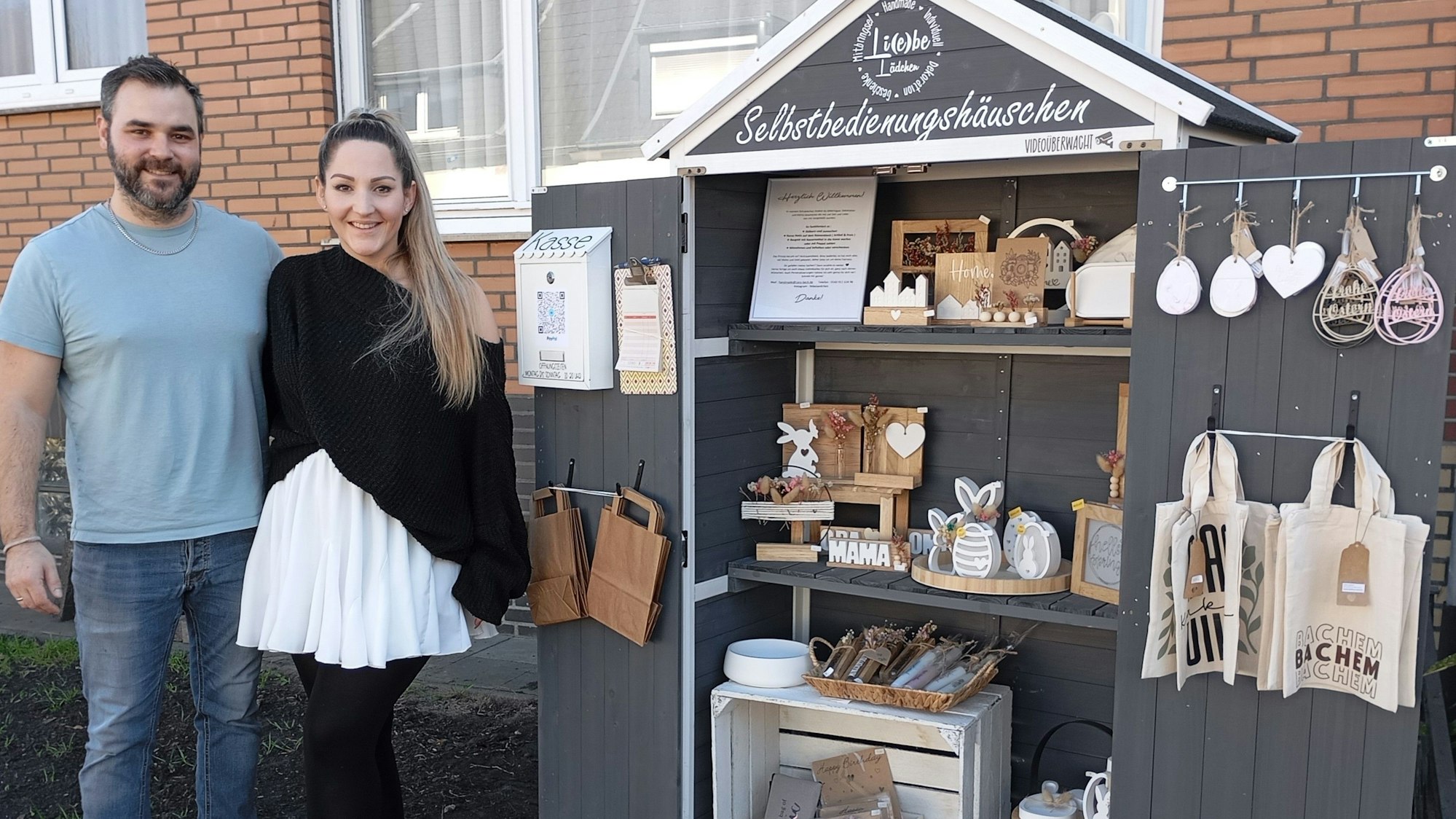Auf dem Bild ist ein Ehepaar vor einem selbst gebauten Verkaufsstand zu sehen.
