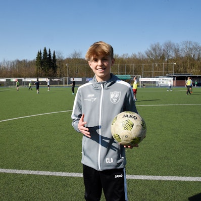 Carl Louis Altwicker steht mit einem Fußball in der Hand auf dem Fußballplatz in Nümbrecht.
