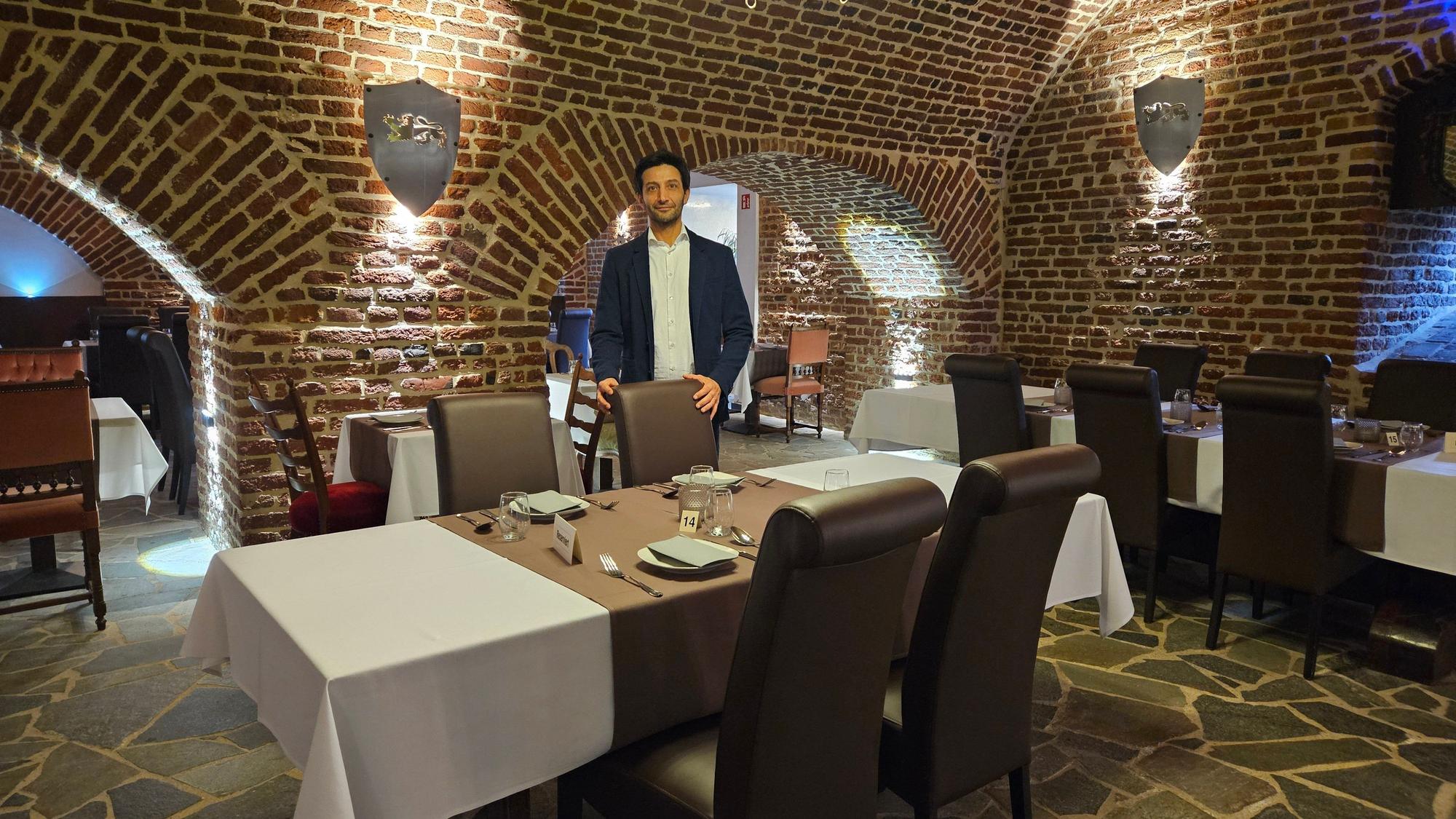 Ein Mann steht an einem gedeckten Tisch in einem Restaurant.
