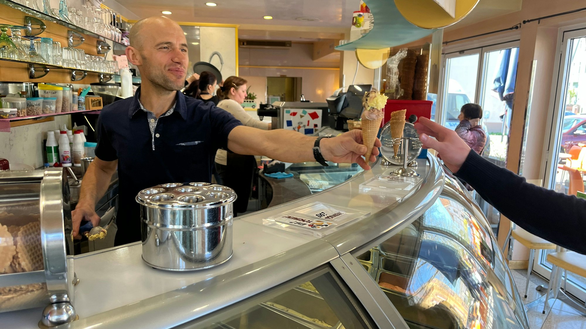 Die Preise für eine Kugel Eis liegen zwischen 1,30 und 1,90 Euro. Während die eine den Preis vom Vorjahr halten, schlagen andere zehn Cent drauf. Jimmi Balla vom Eiscafé Tormen reicht eine Waffel über den Tresen.