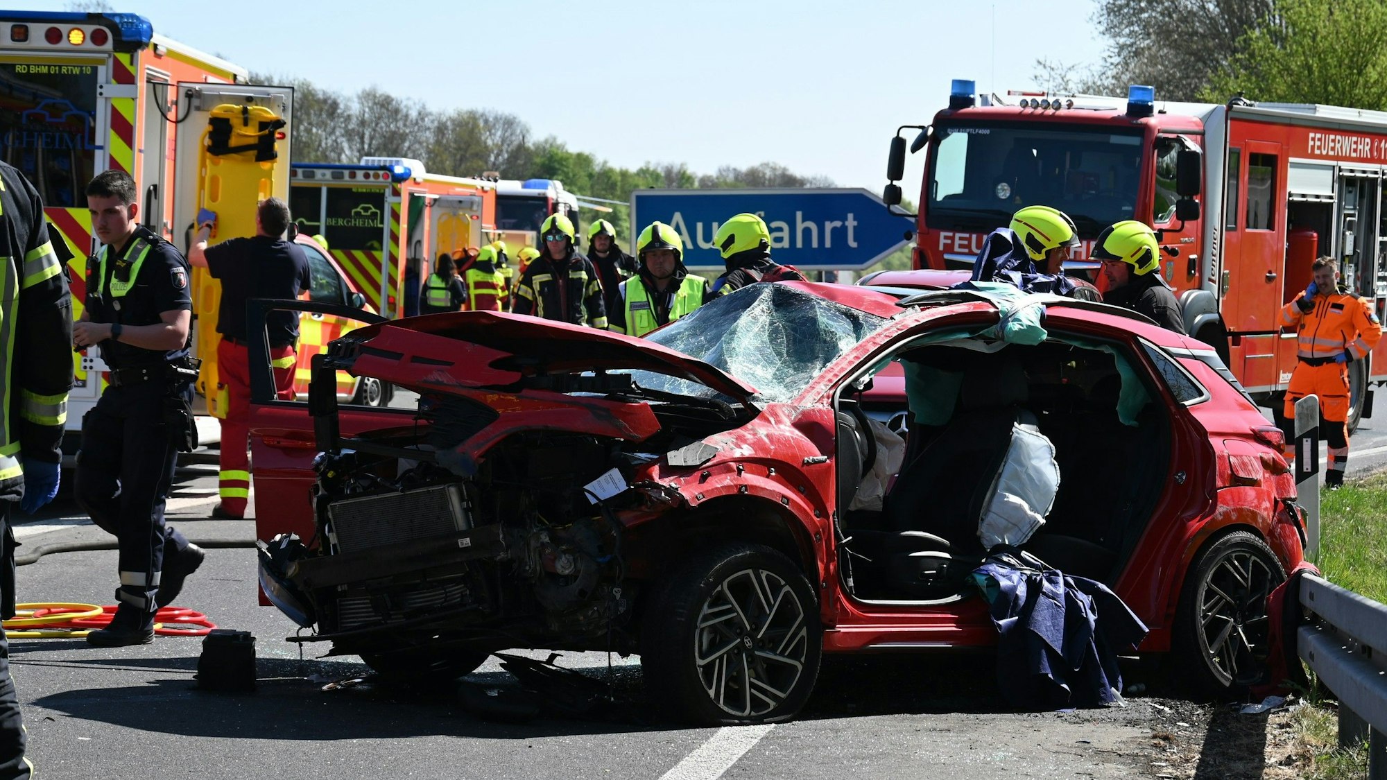 Das Bild zeigt Einsatzkräfte der Feuerwehr auf der Autobahn an einem verunglückten Auto.