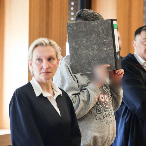 Der angeklagte Krankenpfleger hält sich zwischen seinen Anwälten Volker Breyer (r) und Tanja Tomasso (l) einen Aktenordner vor das Gesicht. Ulrich S. steht wegen Mordes an neun Patienten vor dem Aachener Landgericht.