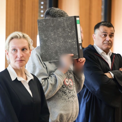Der angeklagte Krankenpfleger hält sich zwischen seinen Anwälten Volker Breyer (r) und Tanja Tomasso (l) einen Aktenordner vor das Gesicht. Ulrich S. steht wegen Mordes an neun Patienten vor dem Aachener Landgericht.
