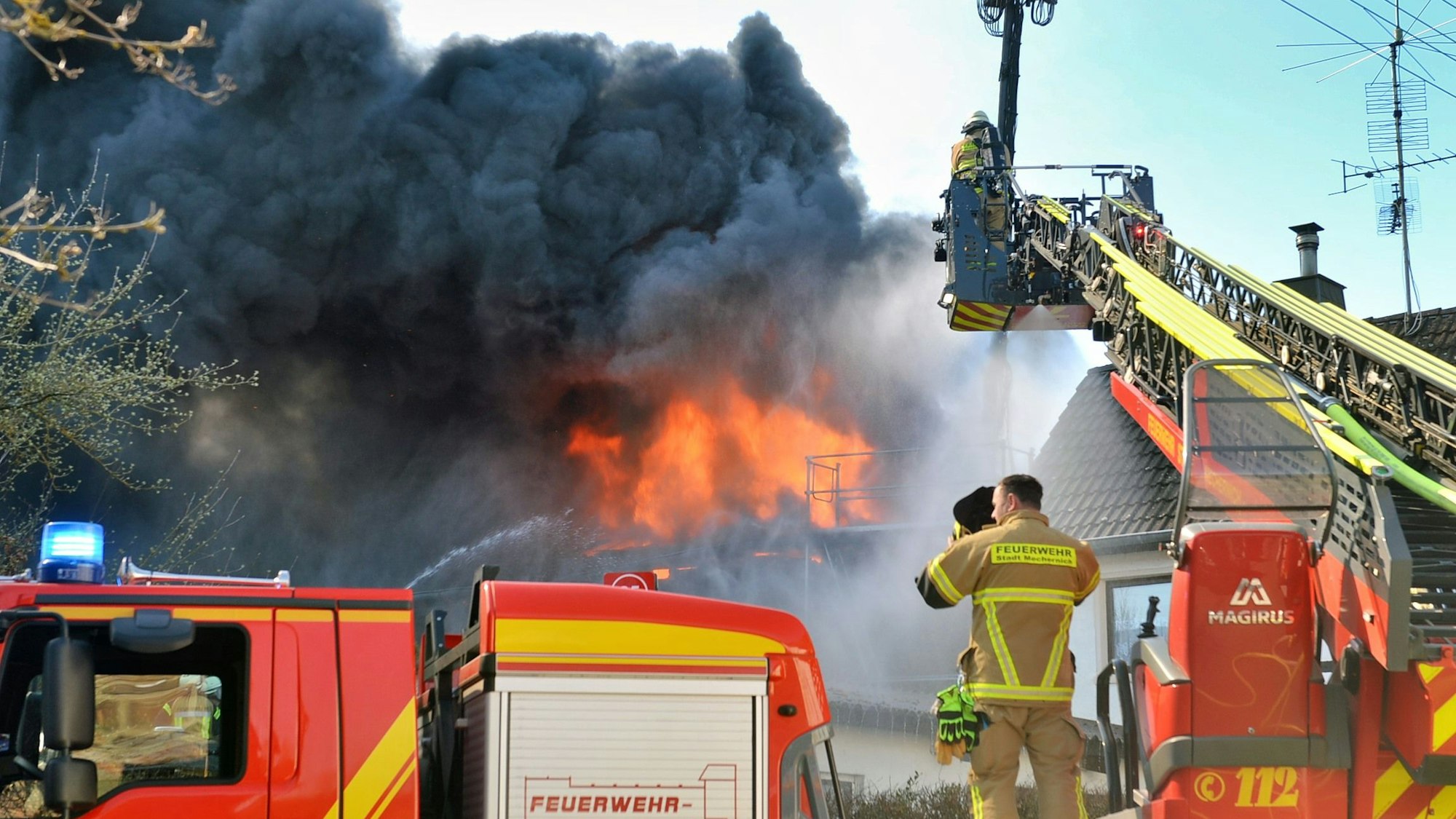 Eine Drehleiter der Feuerwehr steht in Scheven, um aus dem Korb den Brand einer Halle zu löschen.