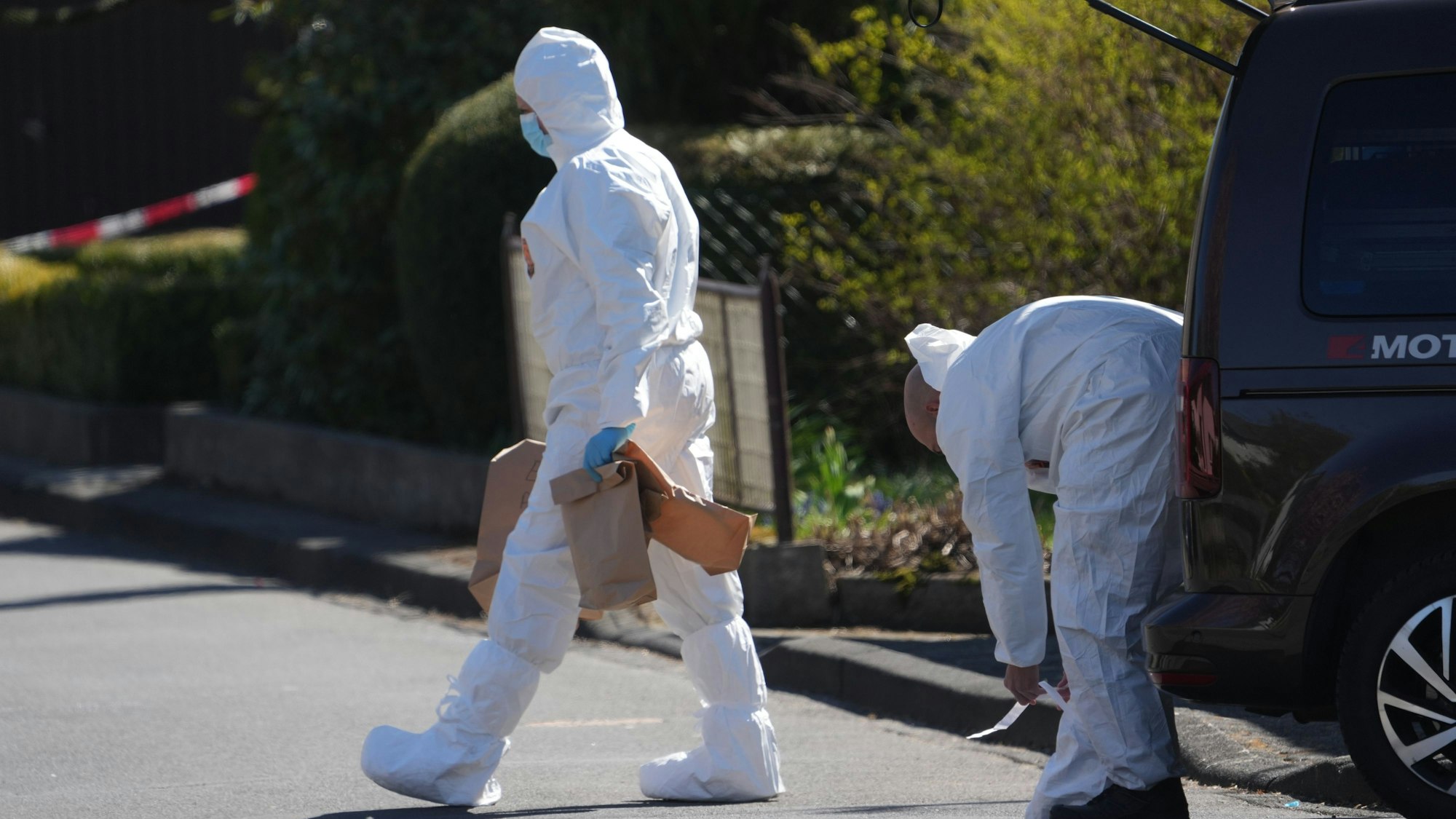 Mitarbeiter der Spurensicherung stehen in einem abgesperrten Areal in Weitefeld im Westerwald. Drei Menschen sind in Weitefeld im Westerwald tot aufgefunden worden.