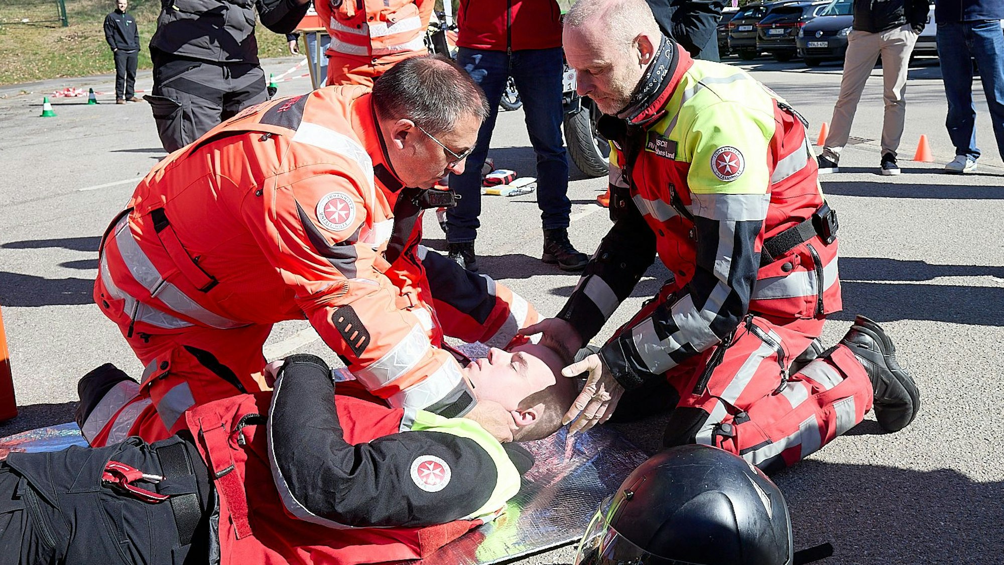 Zwei Einsatzkräfte des Malteser Hilfsdienstes zeigen im Rahmen einer Vorführung, wie Ersthelfer einem verunfallten Motorradfahrer helfen können.
