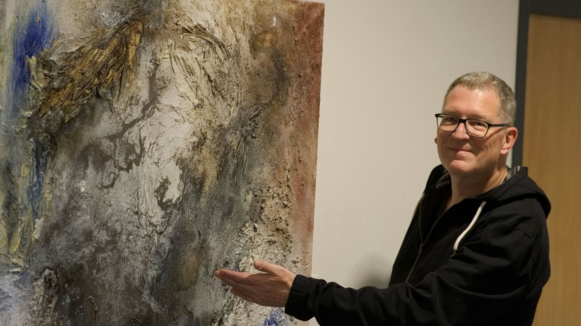 Das Bild zeigt den Künstler vor einem seiner Werke.