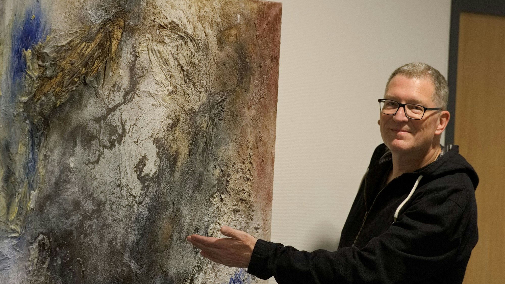 Das Bild zeigt den Künstler vor einem seiner Werke.