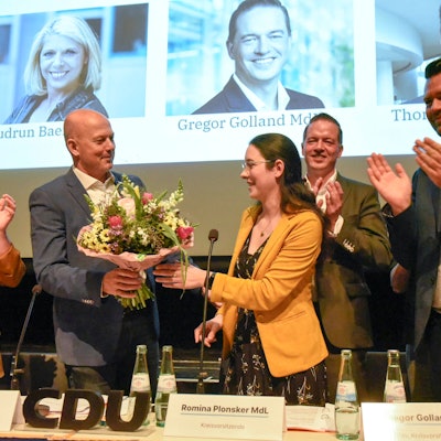 Zu sehen ist Landrat Frank Rock, der Romina Plonsker Blumen überreicht.