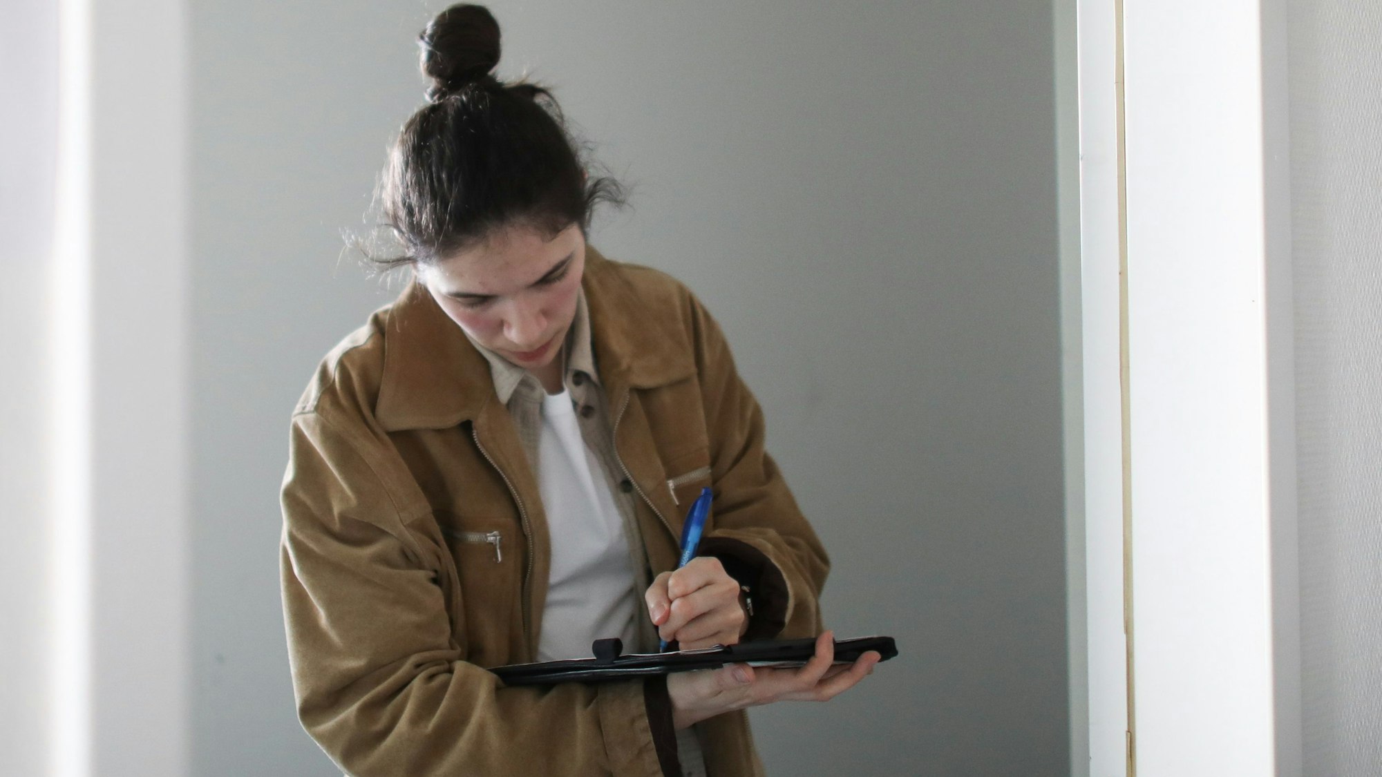 28.03.2025, Köln: Kommissarin Laura schreibt mit Kugelschreiben auf ein Blatt.