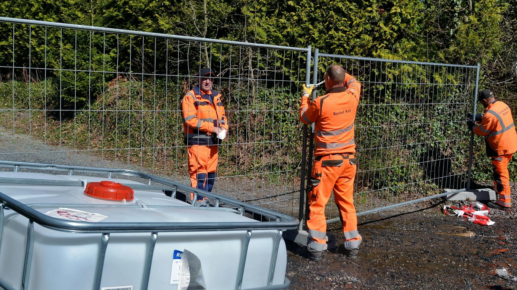 Mitarbeiter des Bauhofs der Gemeinde Kall sicherten nach dem Brand in Scheven das Areal mit Bauzäunen.