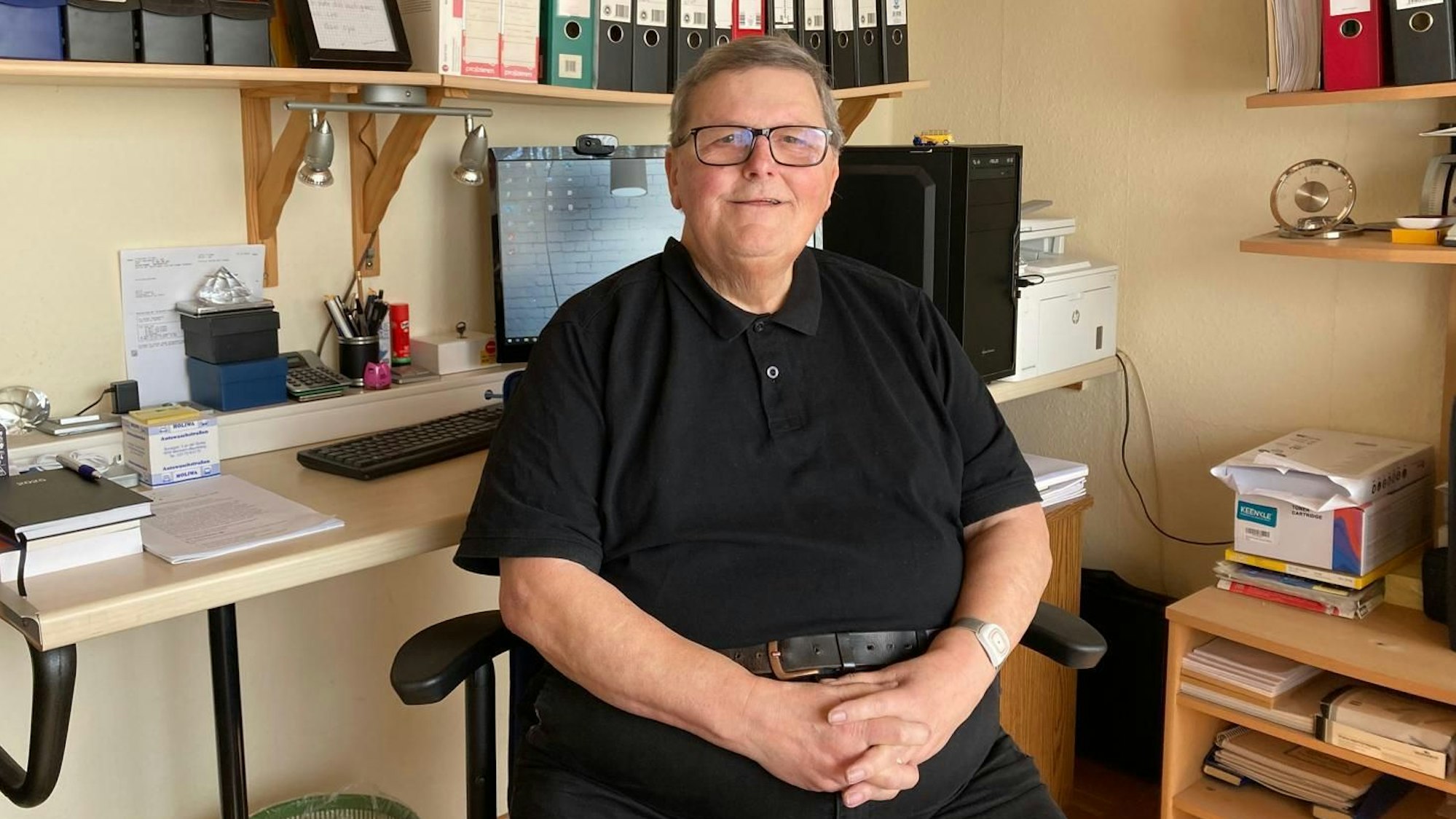 Der Schiedsmann Bruno Kosmala trägt ein schwarzes Polohemd und eine schwarze Jeans.