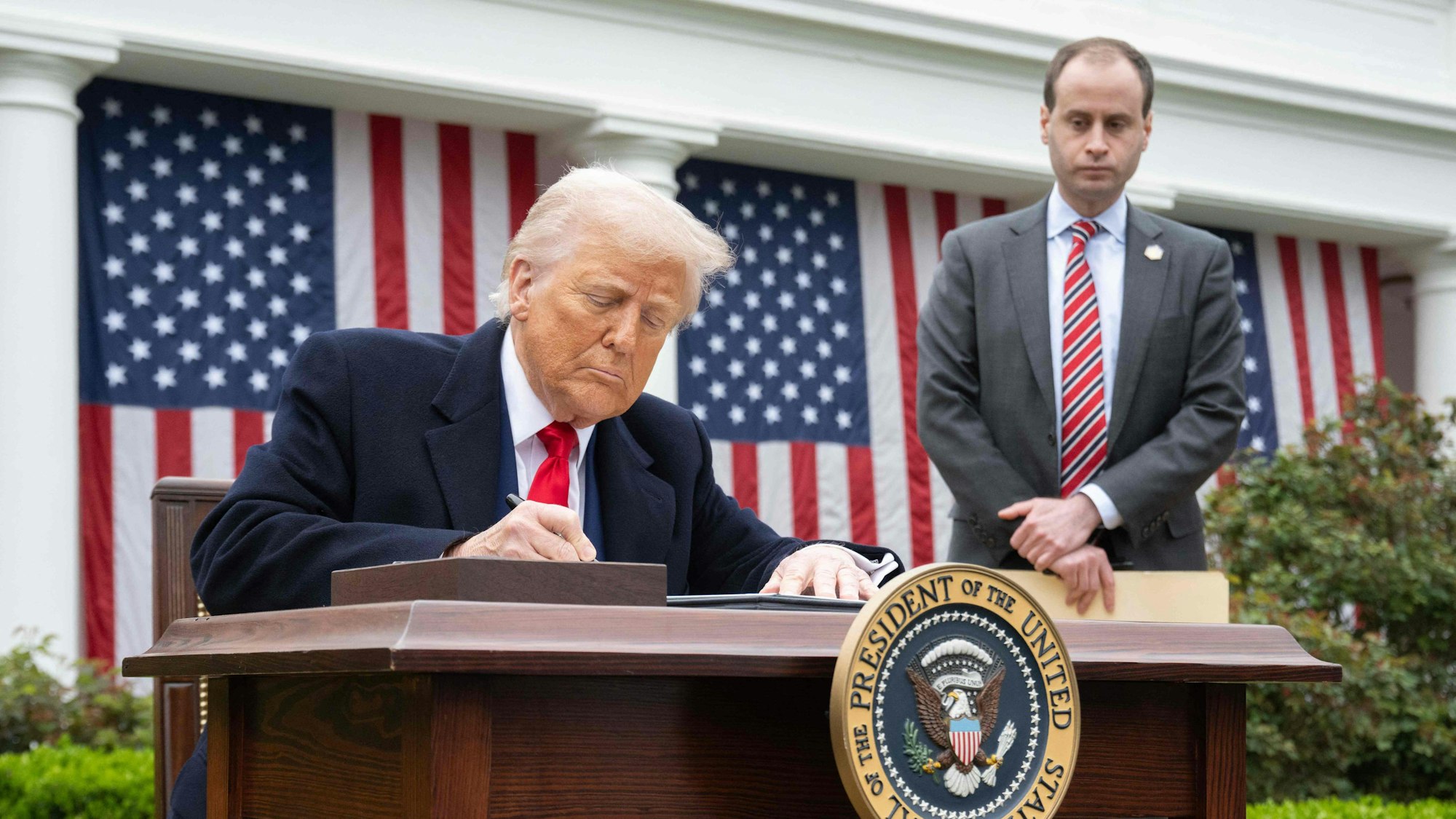 US President Donald Trump signs an executive order after delivering remarks on reciprocal tariffs during an event in the Rose Garden entitled "Make America Wealthy Again" at the White House in Washington, DC, on April 2, 2025. Trump geared up to unveil sweeping new "Liberation Day" tariffs in a move that threatens to ignite a devastating global trade war. Key US trading partners including the European Union and Britain said they were preparing their responses to Trump's escalation, as nervous markets fell in Europe and America. (Photo by SAUL LOEB / AFP)