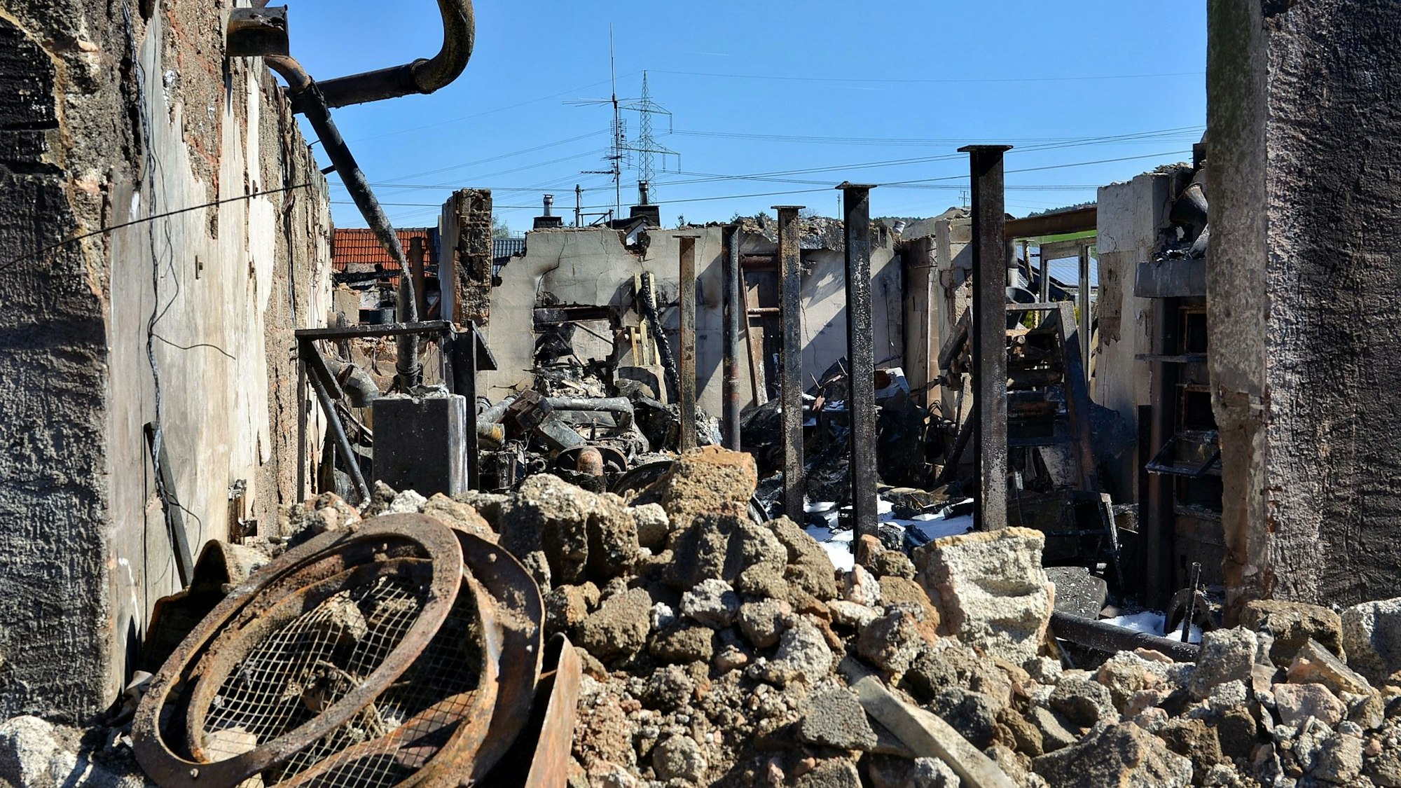 Ein Blick auf die Trümmer der abgebrannten Halle eines Bauernhofs in Kall-Scheven.