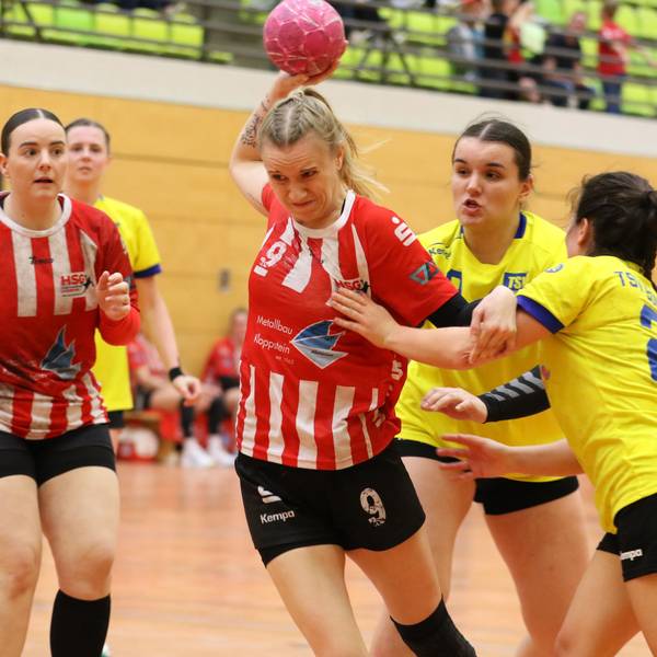 Corinna Schmitz beim Wurf. Eine Gegenspielerin hinter ihr versucht sie noch zu packen, eine Gegenspielerin, die von der Seite kommt, ebenfalls.