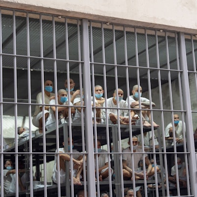 Gefangene schauen aus ihrer Zelle, während Heimatschutzministerin Kristi Noem das Terroristengefängnis in Tecoluca, El Salvador, besichtigt.