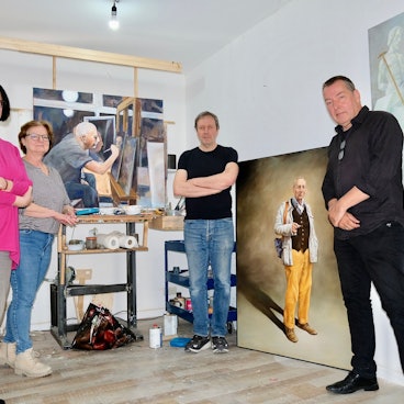 Vier Personen stehen in einem Kunstatelier