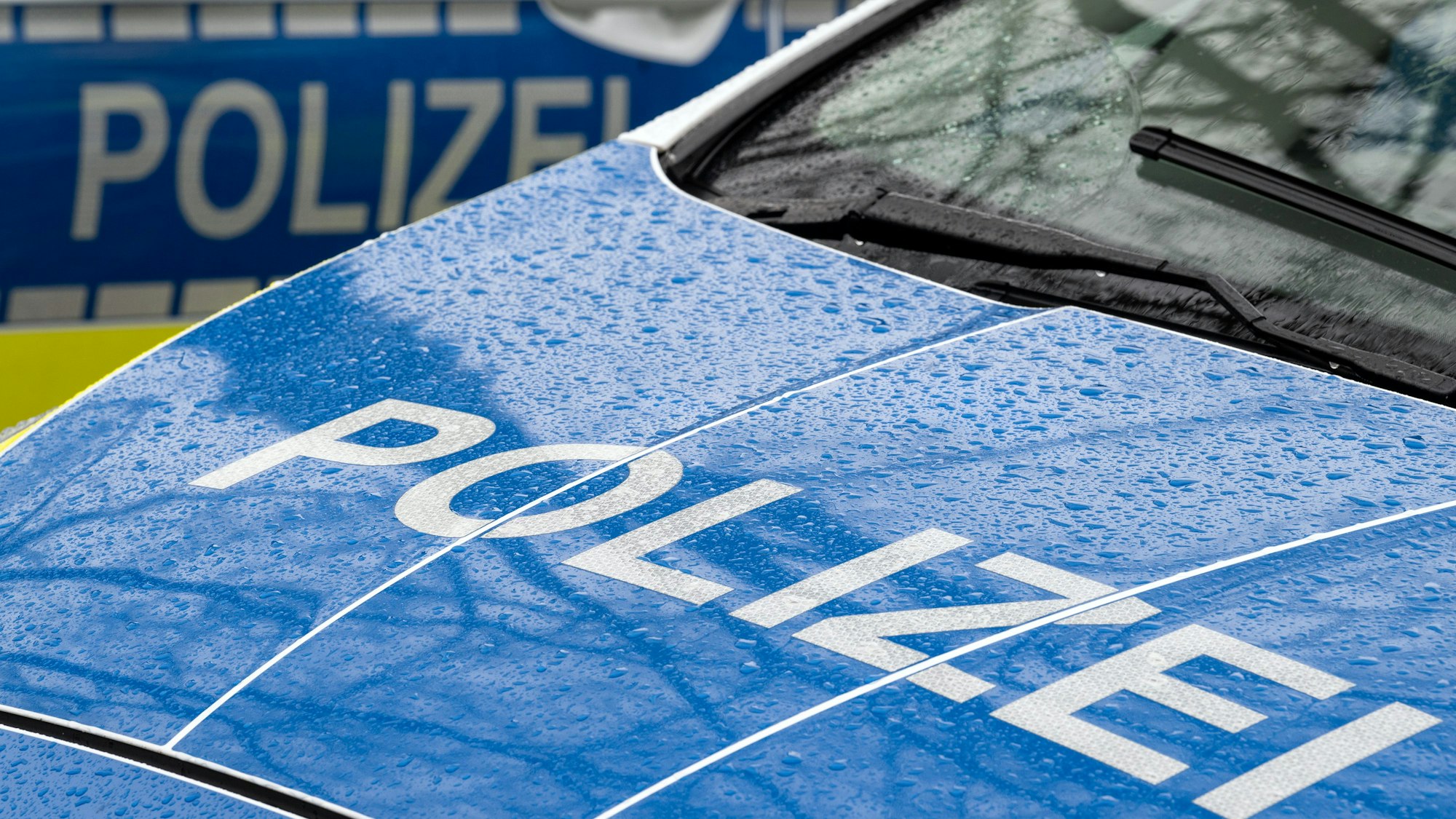 Der Schriftzug "Polizei" auf der Kühlerhaube eines Autos