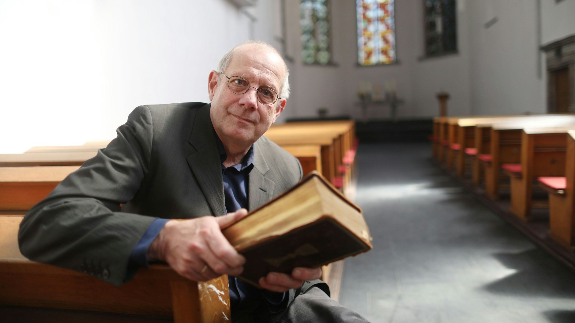 Pfarrer Mathias Bonhoeffer mit einer Familienbibel, in der auch die Geburt seines Großonkels Dietrich Bonhoeffer (1906 bis 1945) eingetragen ist