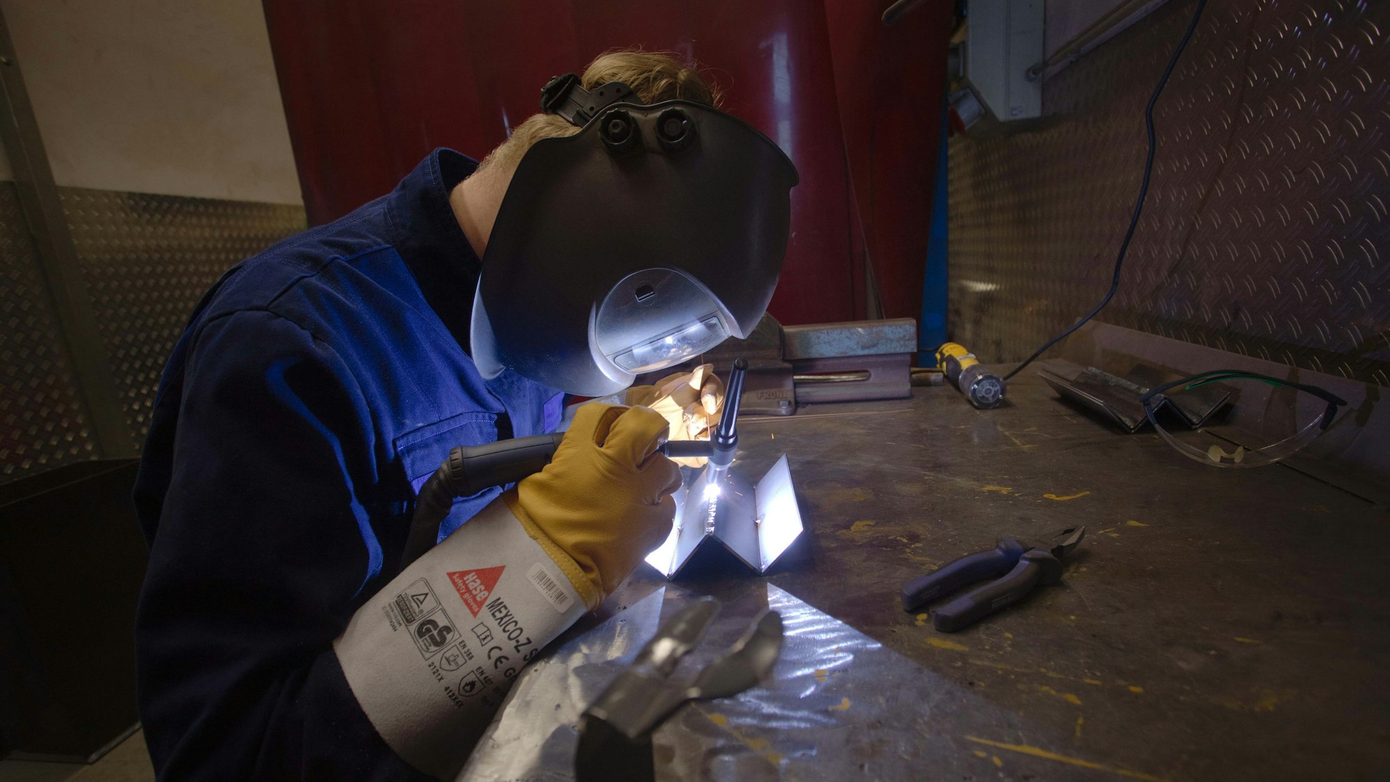 Ein junger Mann schweißt in einer Ausbildungswerkstatt.
