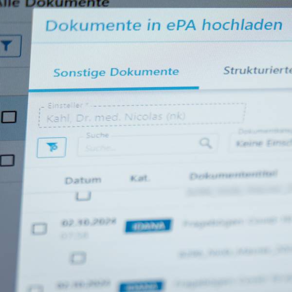 Ein Hausarzt lädt in seiner Praxis Dokumente in eine elektronische Patientenakte „ePA“.
