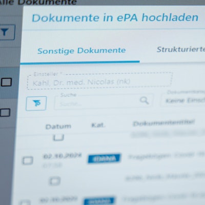 Ein Hausarzt lädt in seiner Praxis Dokumente in eine elektronische Patientenakte „ePA“.