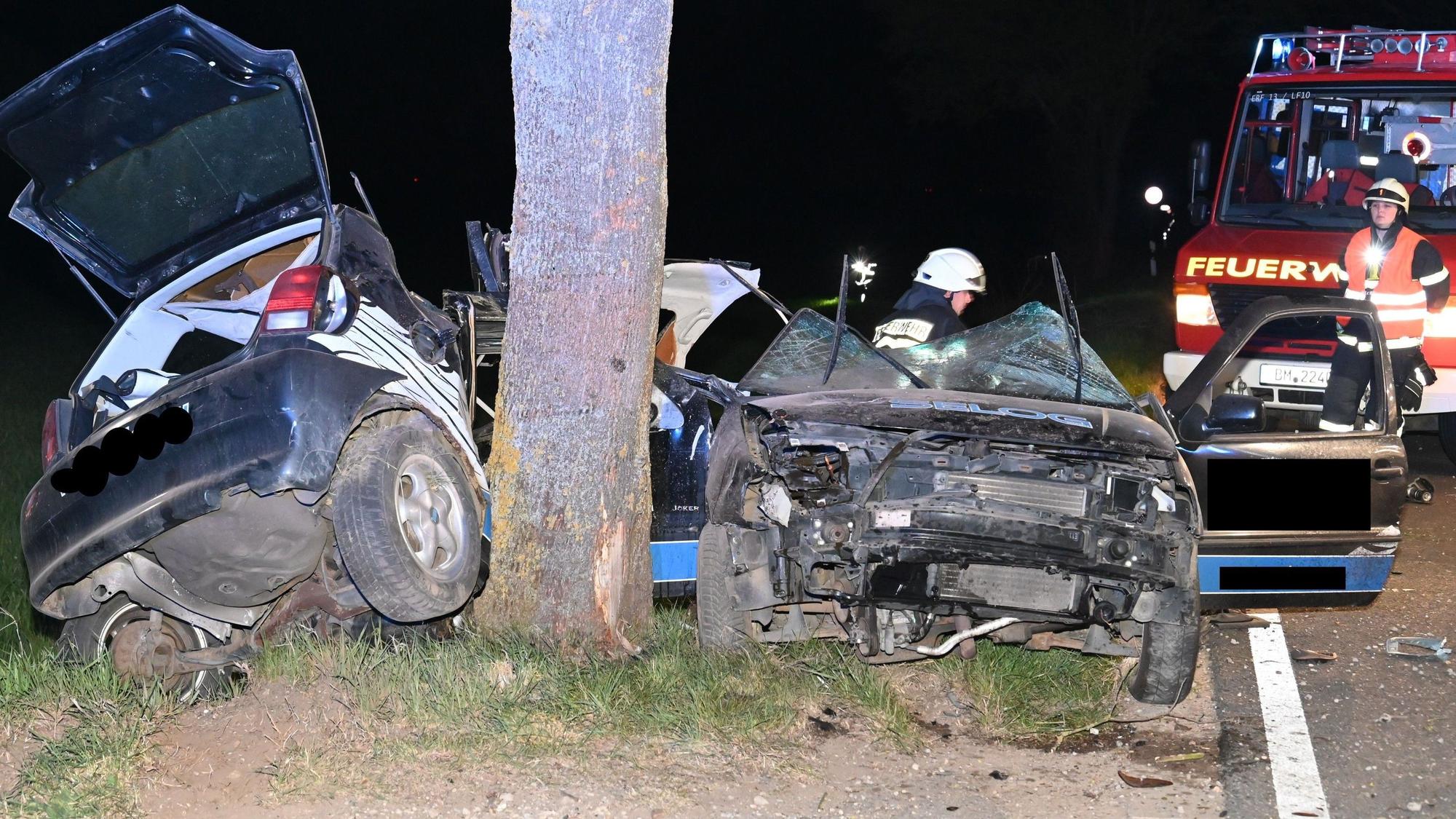 Das Bild zeigt Einsatzkräfte der Feuerwehr neben einem verunglückten Pkw.