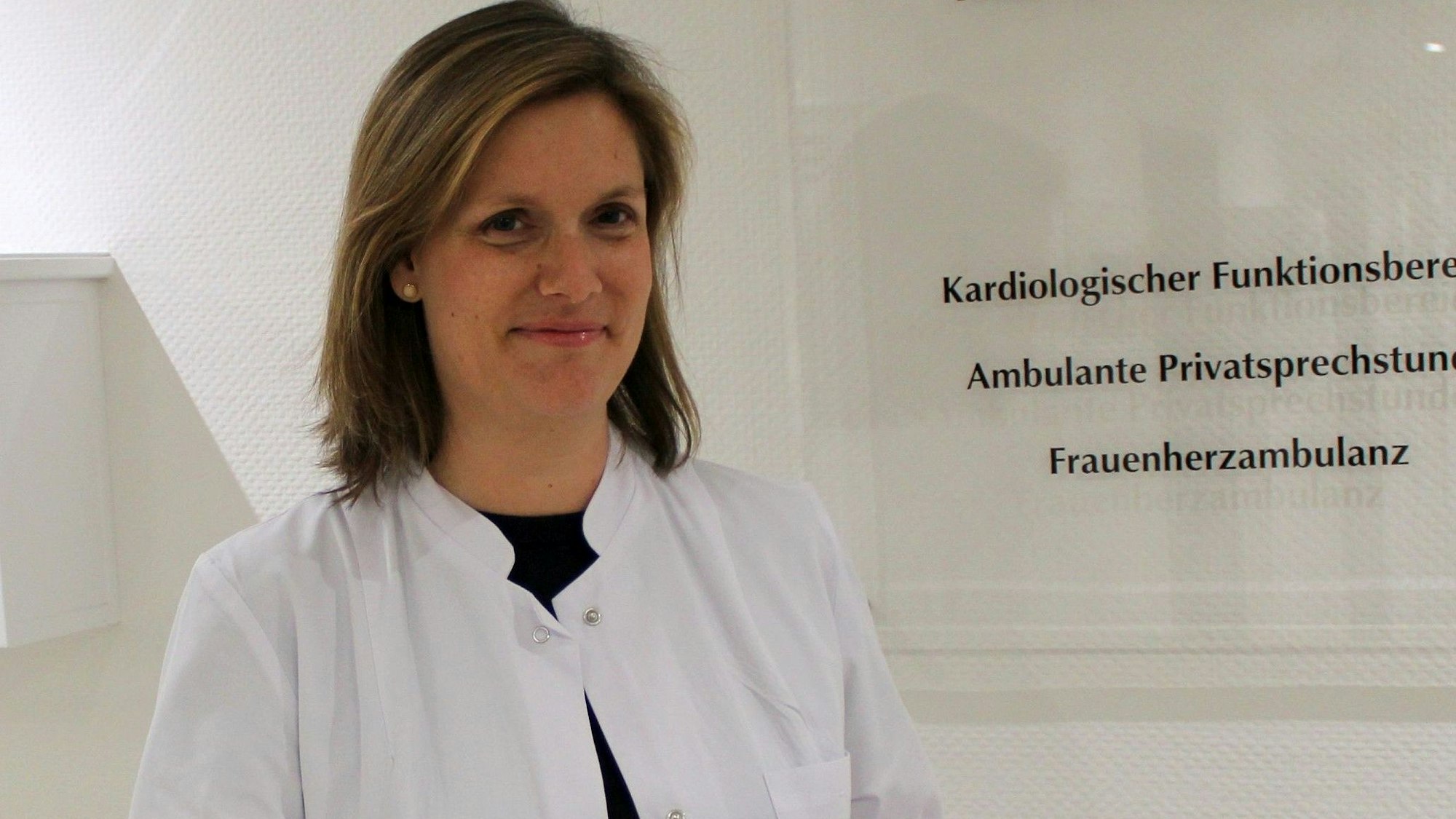 Auf dem Bild ist das Portrait einer Ärztin zu sehen.