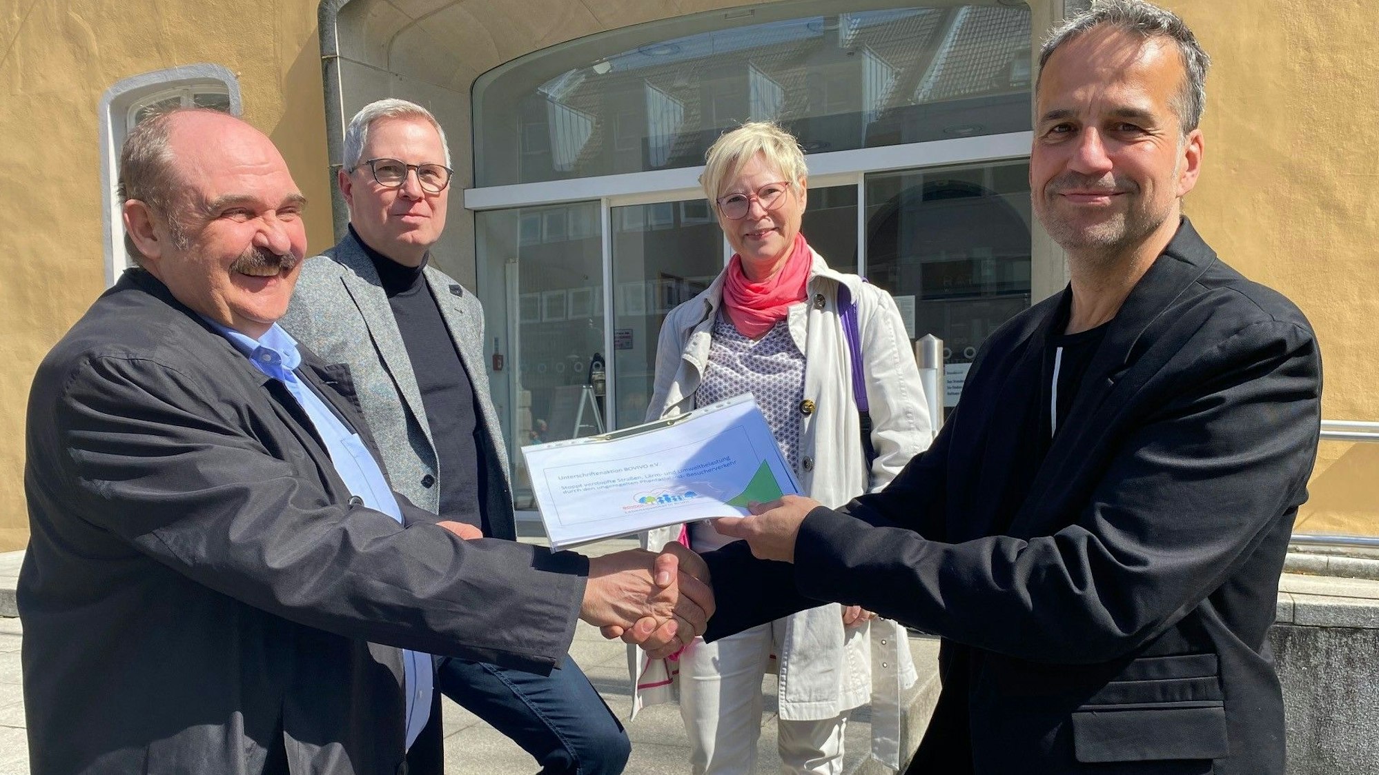 Zu sehen sind drei Mitglieder des Vereins Bovivo, die Ralf Ritter die gesammelten Unterschriften überreichen.