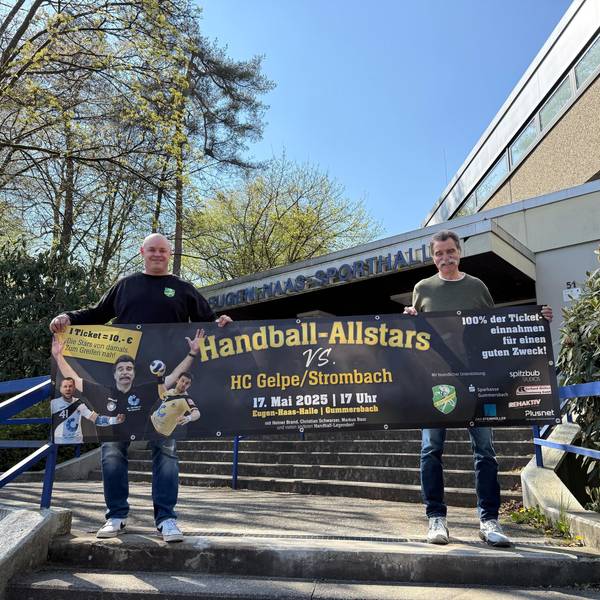 Dass Bild zeigt zwei Handballer, die ein Werbebanner hochhalten.