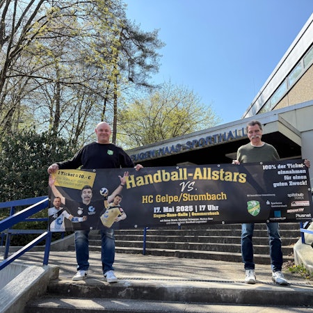 Dass Bild zeigt zwei Handballer, die ein Werbebanner hochhalten.