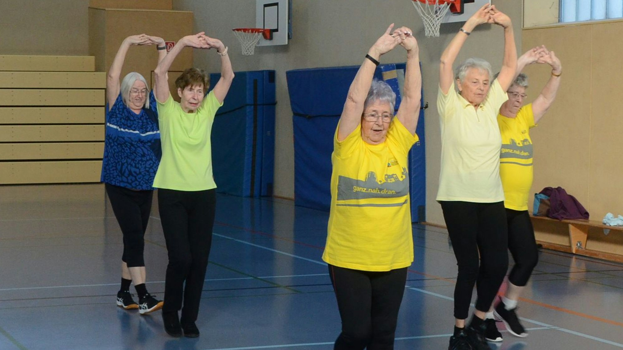 Seniorinnen beim Sport in einer Turnhalle.