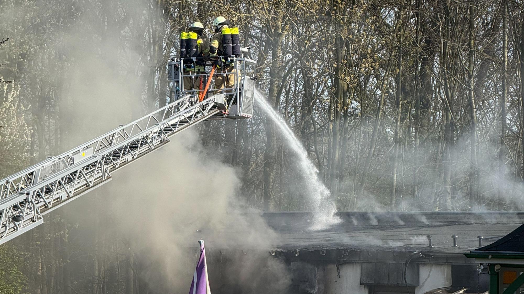 Feuerwehrleute löschen ein brennendes Gebäude.