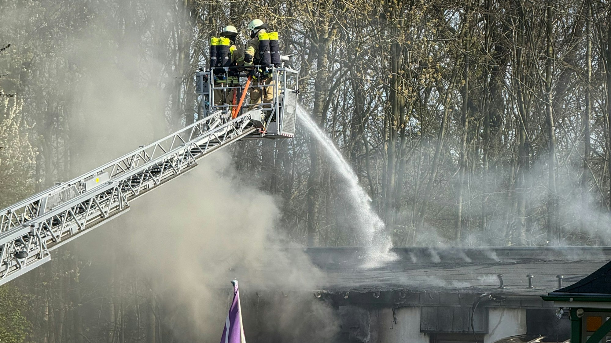 Feuerwehrleute löschen ein brennendes Gebäude.