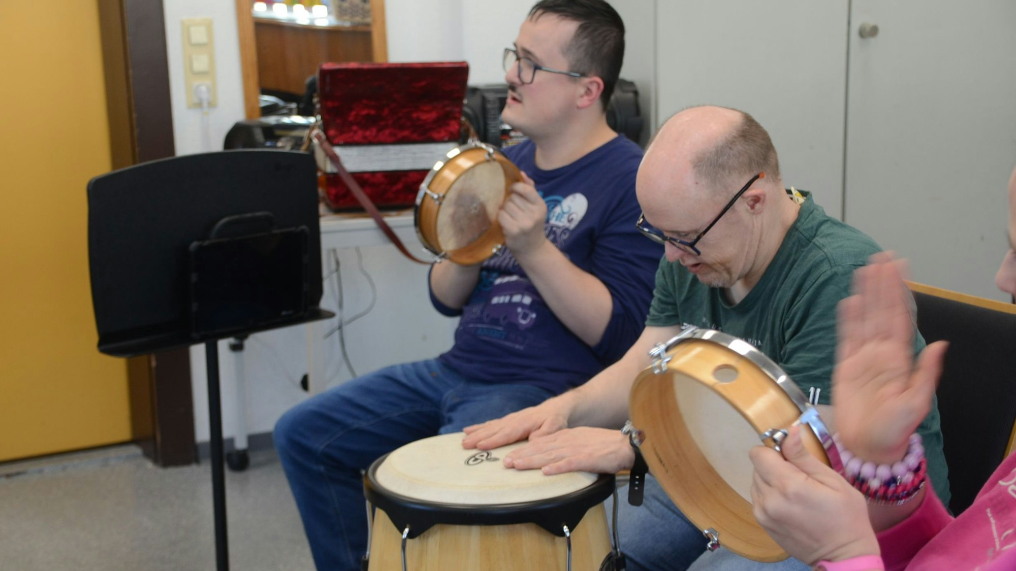Zwei Männer trommeln und schlagen ein Tamburin.