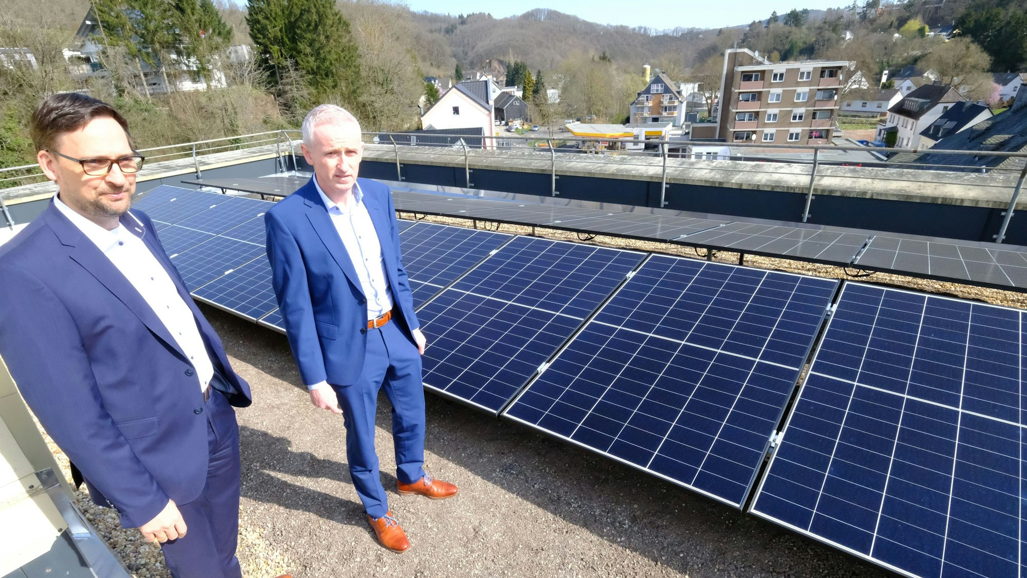 Kai Zinken (r.) und Abteilungsleiter Jörg Schröder stehen auf dem Dach neben PV-Modulen.